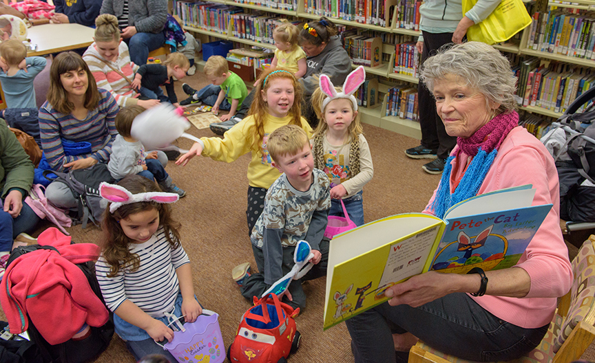 Teacher reading a book to children